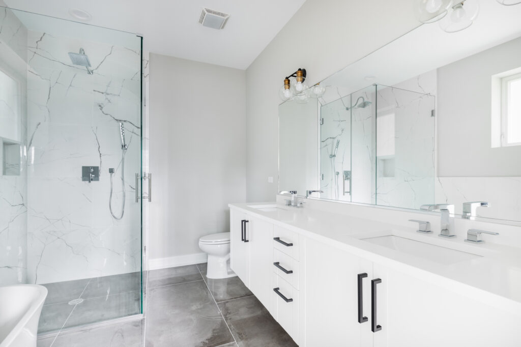 A modern, white luxury bathroom with black hardware and chrome